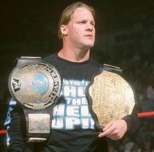 Undisputed WWE Champion Chris Jericho standing in the ring with two championship belts.